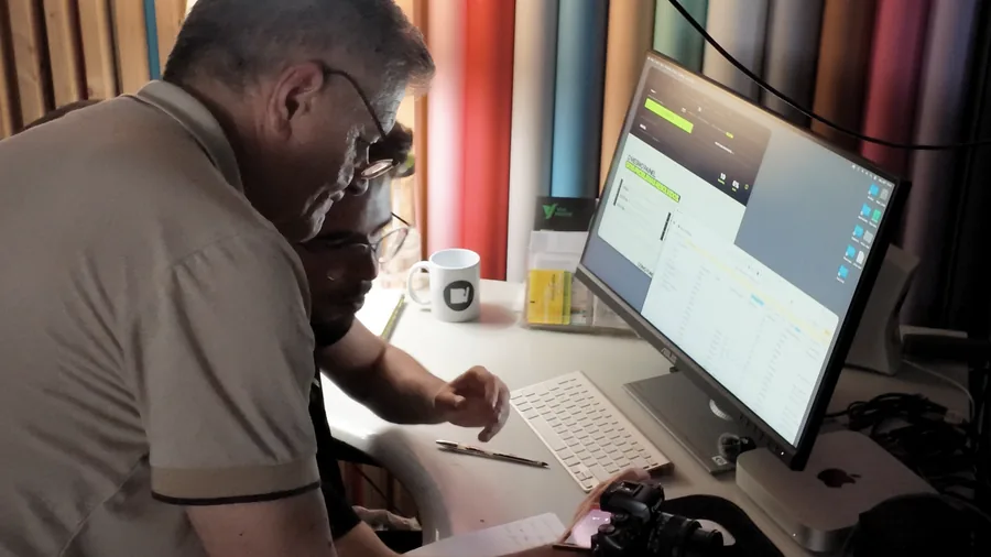 Duas pessoas debruçadas sobre um monitor, a rever o painel da BoldIvy